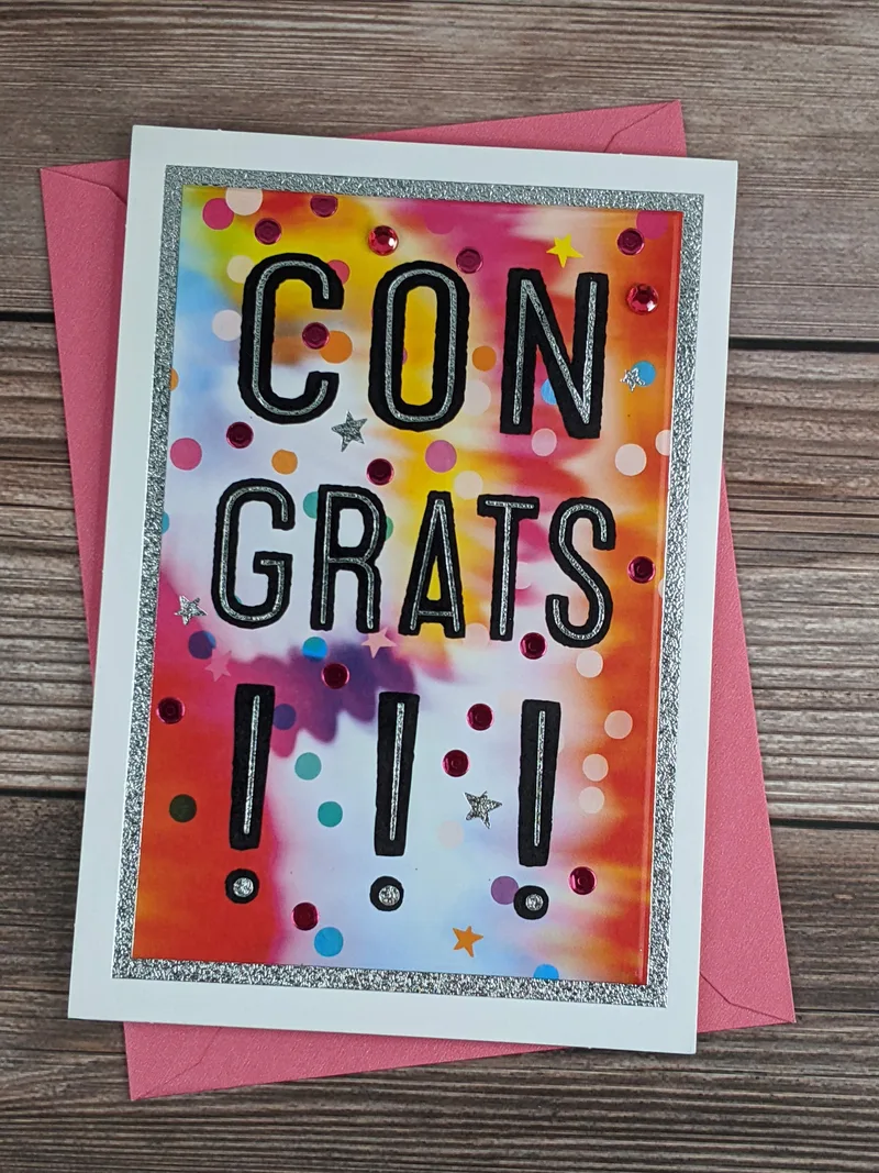 A graduation greeting card with vivid colors and pink gems, intended for a female.