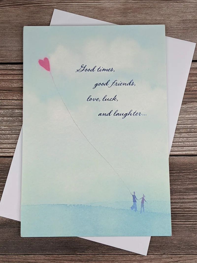 A greeting card for someone starting something new in life, with an image of two people flying a kite.