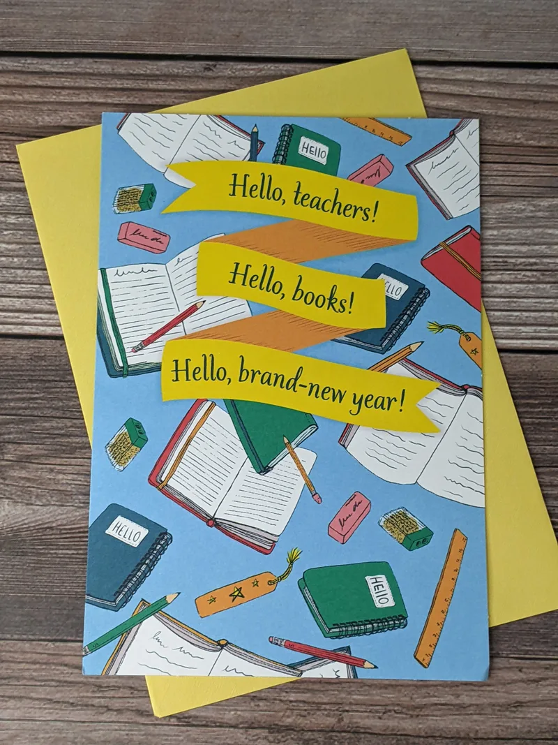 A blue greeting card with images of school supplies and books, celebrating a student going back to school.