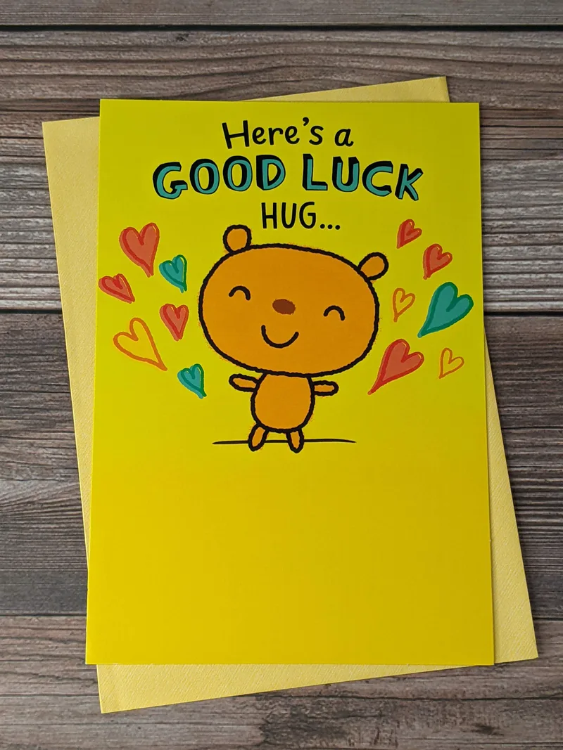 A yellow greeting card for back-to-school with an image of a bear ready for a hug and some hearts.