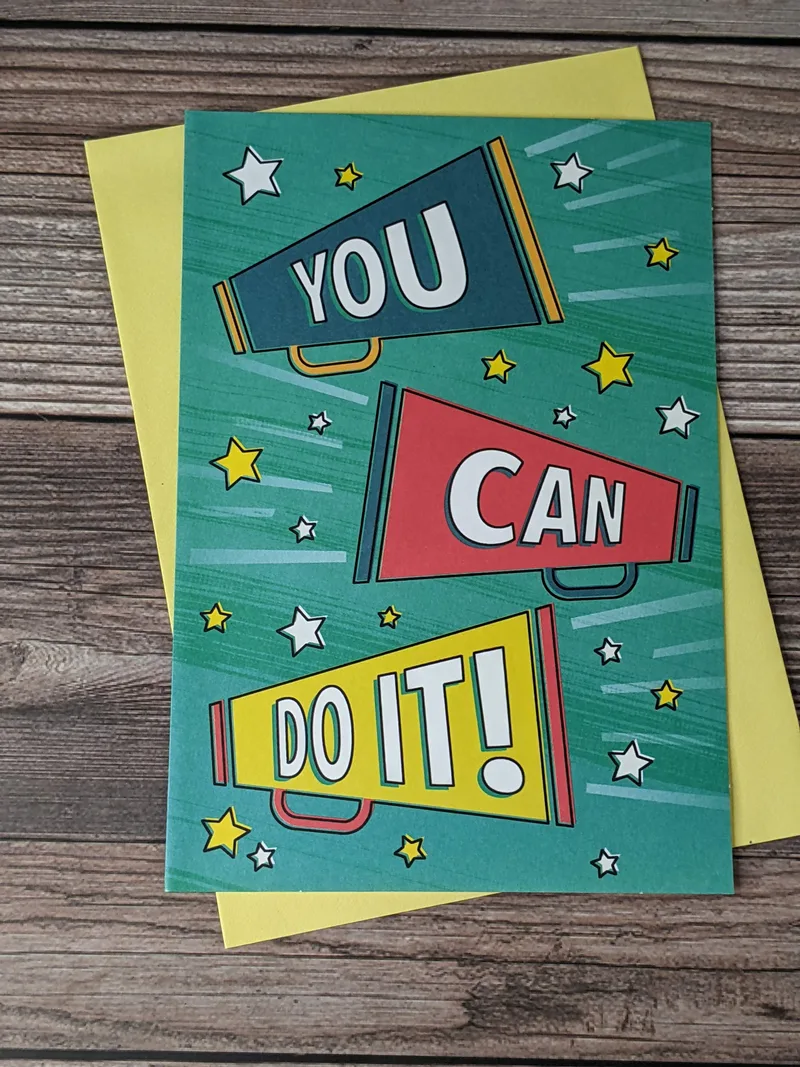 A back-to-school greeting card for a child, with a teal cover that has images of megaphones saying, "You can do it!"
