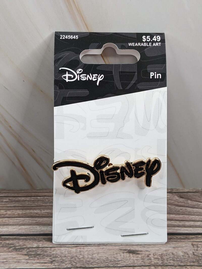 A collectible metal lapel pin with black enamel lettering, spelling out "Disney" in a logo format.