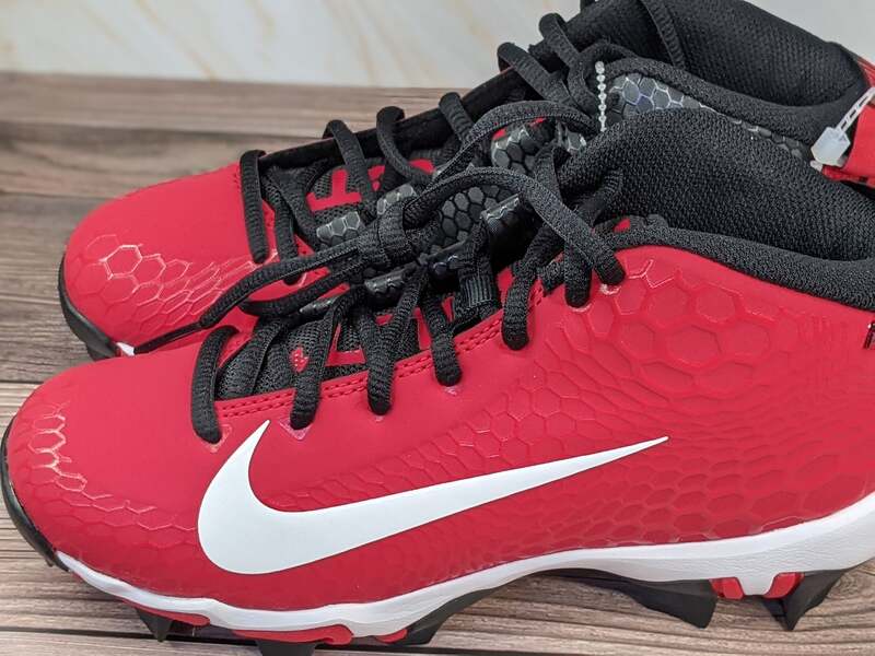 Red Nike cleats with black laces and a white swoosh. Size 2.5 youth.