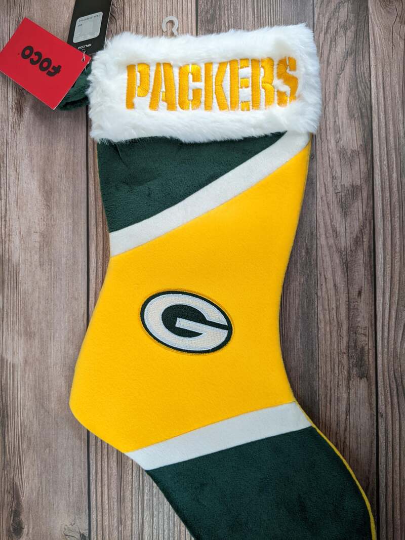 A Christmas stocking with the Green Bay Packers NFL logo, in white, green and yellow.