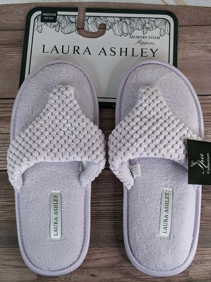 A pair of lavender memory foam slippers for women that are flip-flop style.