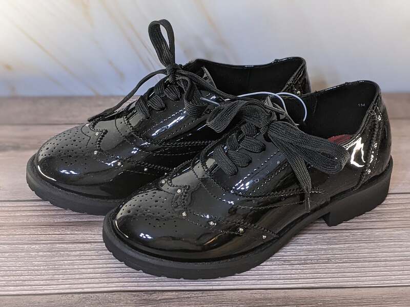 A pair of shiny black discounted patent leather shoes for girls by Jellypop.
